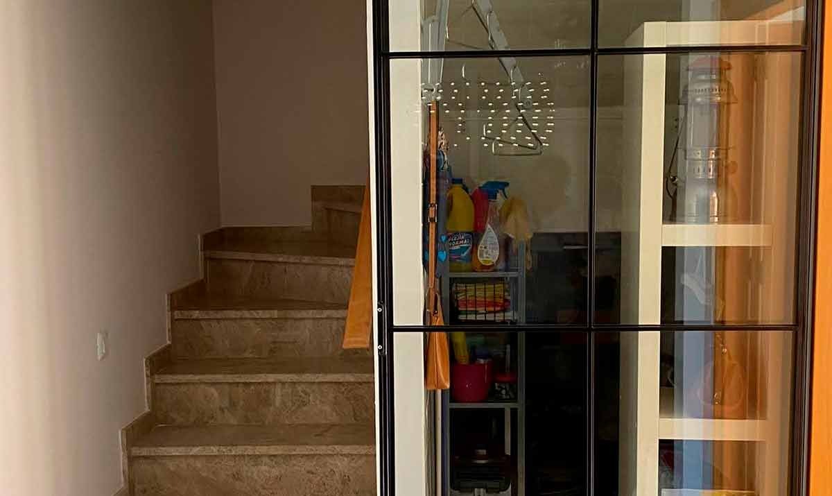 Puerta corredera de escalera y hueco de escalera en hierro color negro y cristal